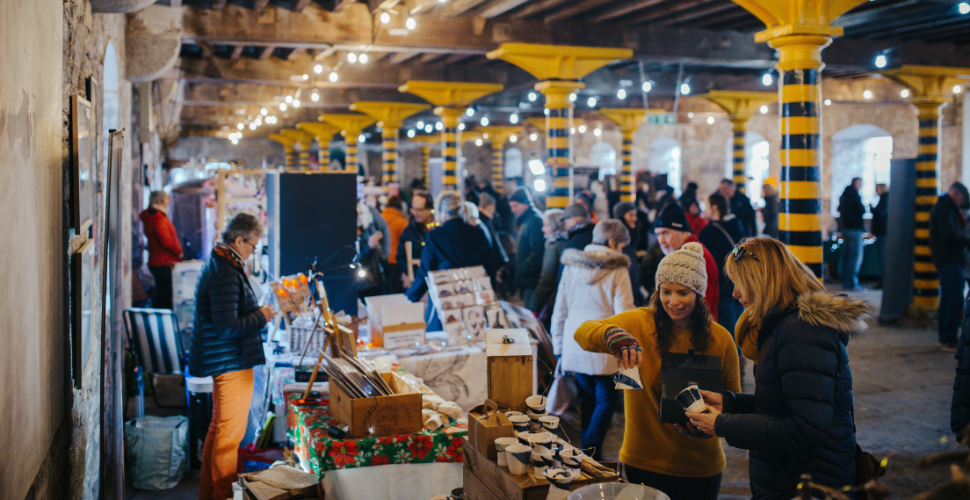 A photograph of the people browsing one of the markets at the Royal William Yard